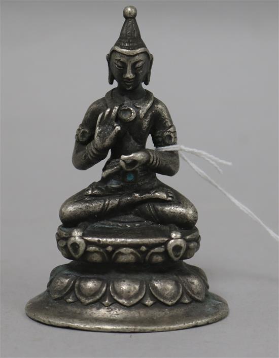 A white metal Buddha